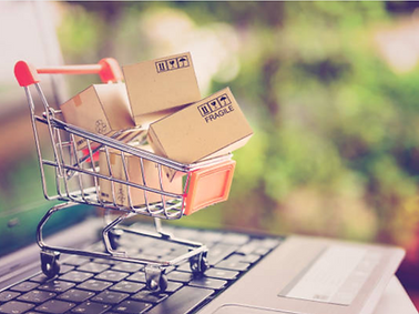 Carrinho de compras com caixas sobre um notebook