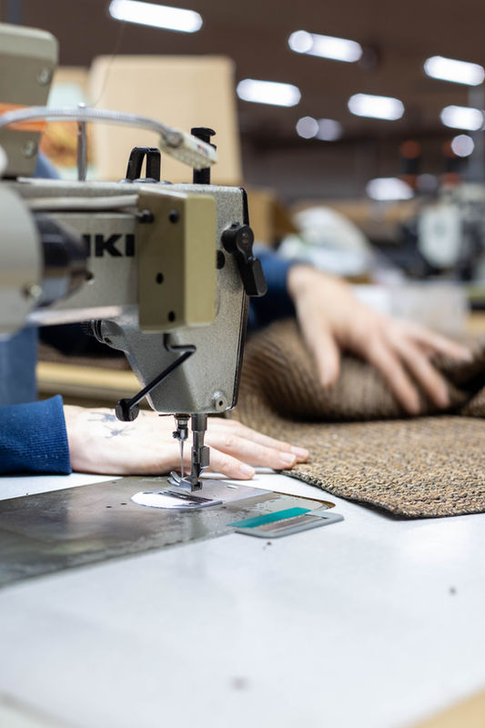 Stikwerk aan de naaimachine in ons confectieatelier