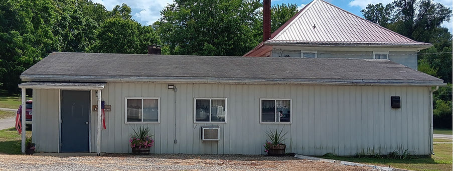 Shingle roof with white 2 story building in background