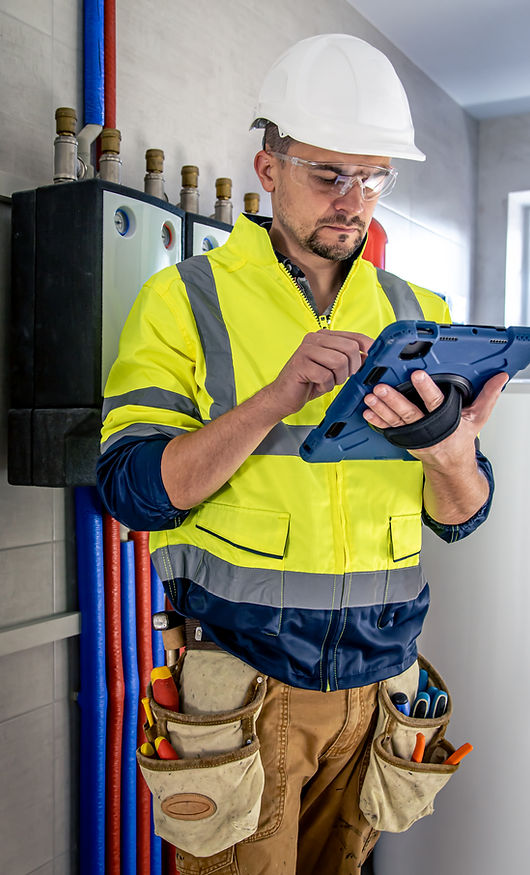man-electrical-technician-working-switchboard-with-fuses-uses-tablet.jpg