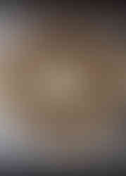 Fully shaped cinnamon star bread on parchment paper, brushed with egg wash and ready to bake — layers visible with cinnamon swirls.