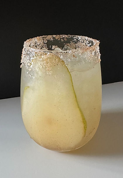 Spiced Pear Margarita served on the rocks in a short glass, rimmed with cinnamon sugar and garnished with a fresh pear slice.