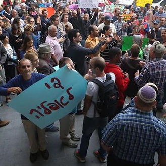 תמונה מתוך הפגנה, אחד המפגינים אוחז שלט עליו כתוב "די לאפליה"