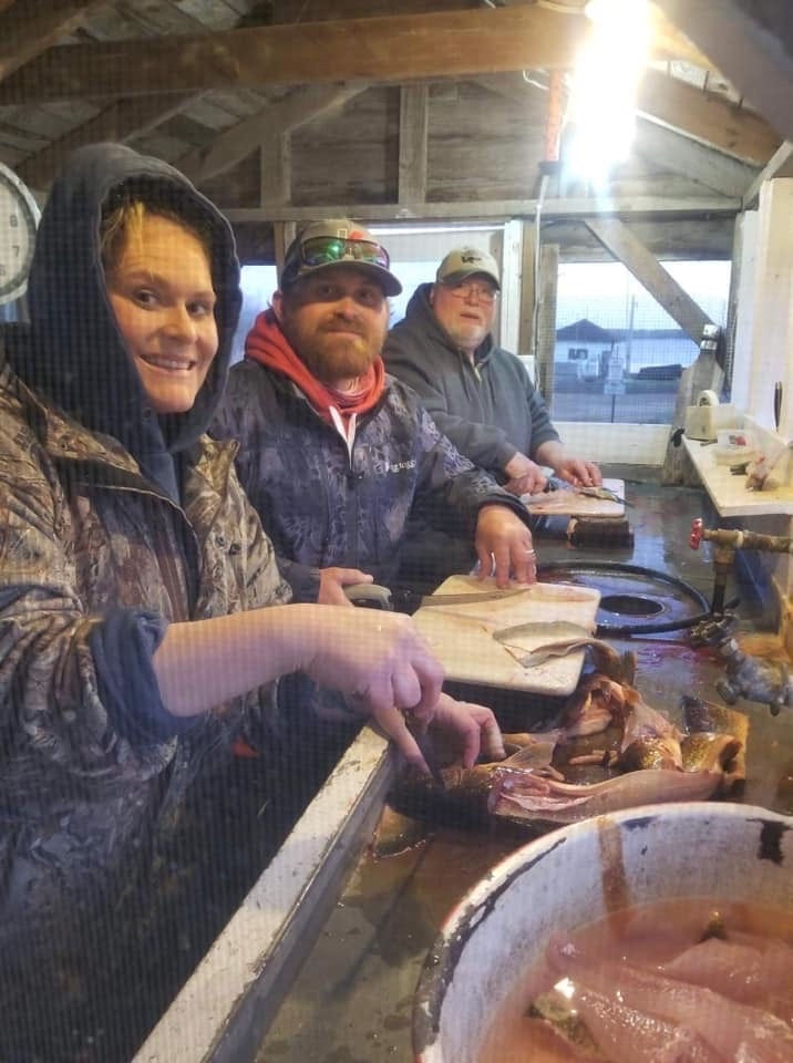 Guests cleaning their fall fishing catch in the screened fish cleaning house at Kitchi Landing Resor