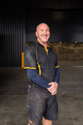 Jeda Logistics team member standing in front of a warehouse with moving boxes.