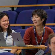 Attendees using laptops and taking notes during a session.