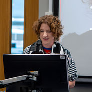 Presenter speaking behind a lectern during a workshop session.