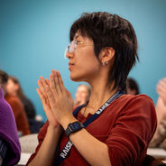 Conference attendee applauding during a session.
