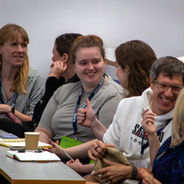 Attendees in discussion while seated in a lecture theatre.