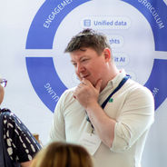 Attendees in conversation at an exhibition stand.