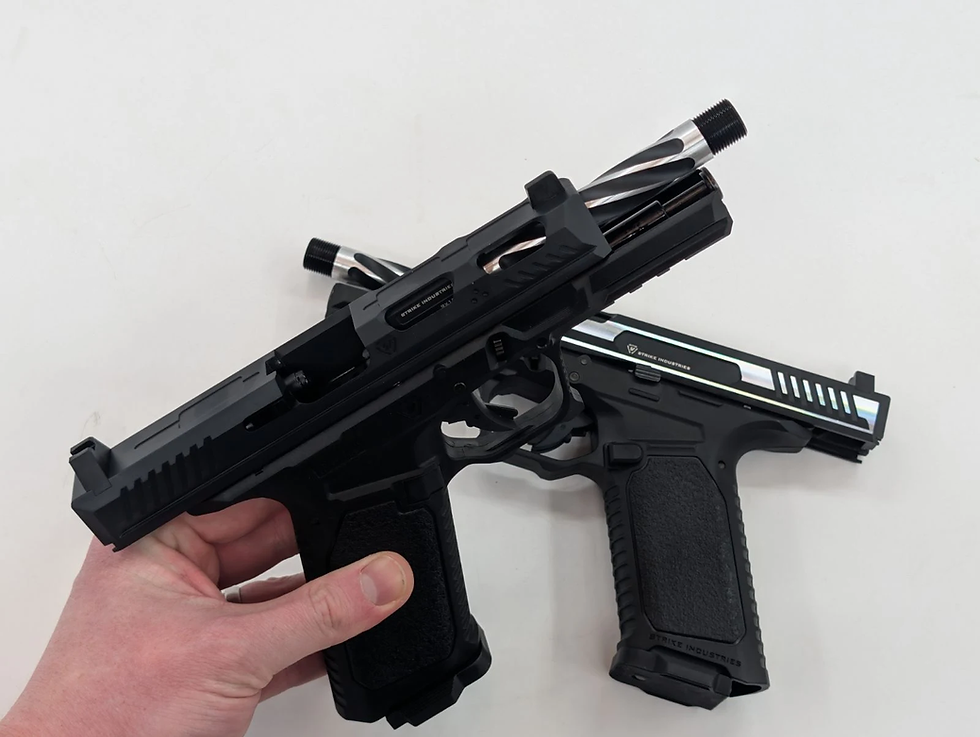 A hand holds a black pistol with one with silver details on a white background. Visible text includes "Strike Industries."