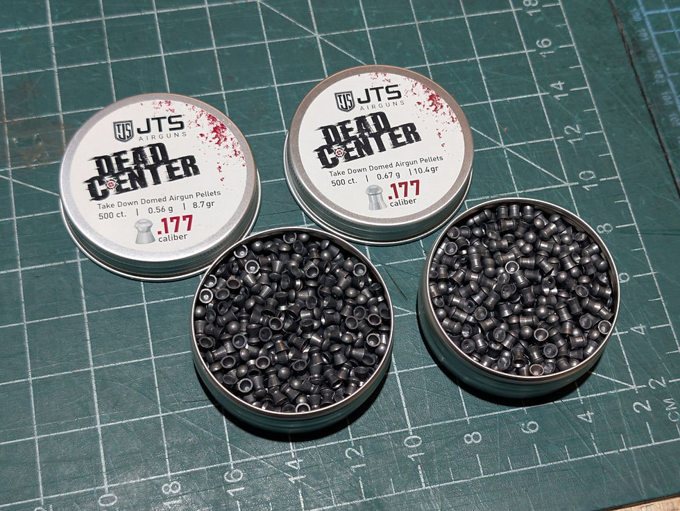Tins of JTS Dead Center .177 caliber airgun pellets on a green grid cutting mat. Pellets are visible in open tins.