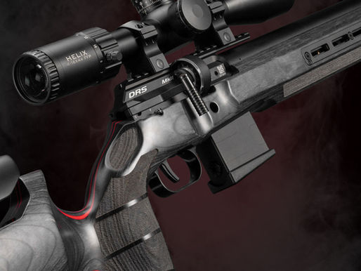 Close-up of a black FX DRS Mk2 rifle with scope and magazine against a dark smoky background.