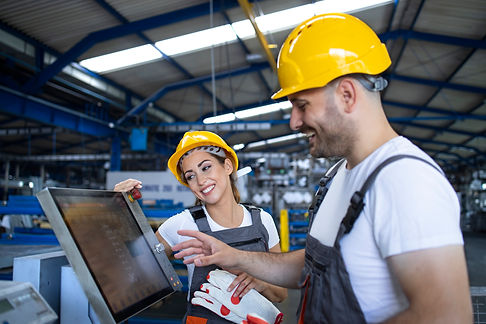 factory-worker-explaining-trainee-how-to-operate-industrial-machine-using-new-software-on-