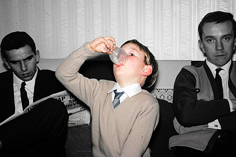 a young man drinking from a glass
