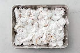 putting karaage chicken into a pan of coating before air frying