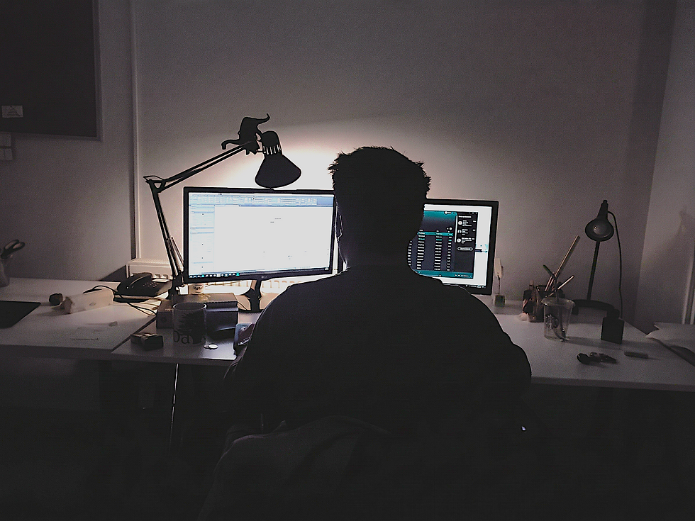 man at a desk working on a computer at night
