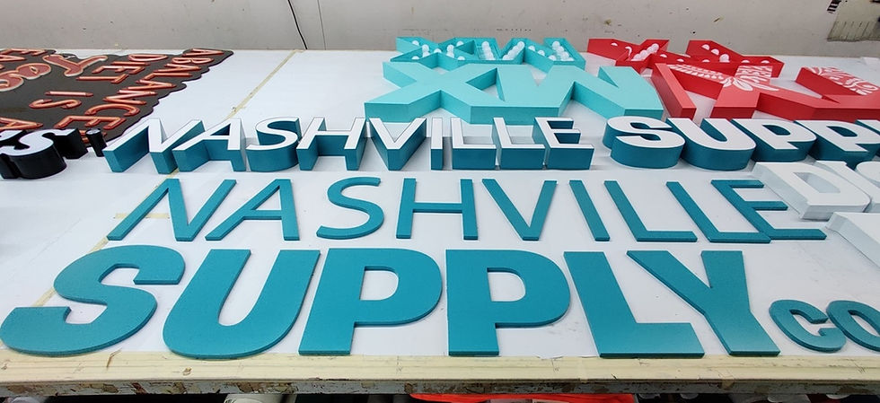 Close-up view of a sign company workshop with various sign materials and tools