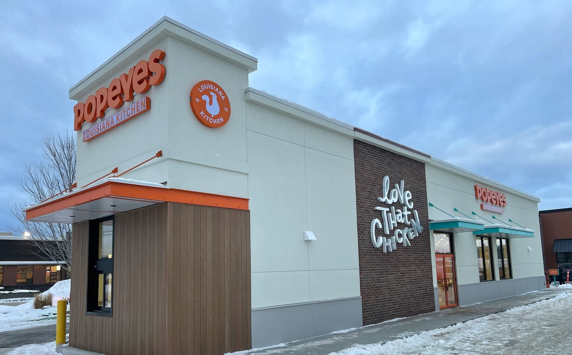 Popeyes Restaurant on a snowy day with dimensional signage all around the restaurant.w