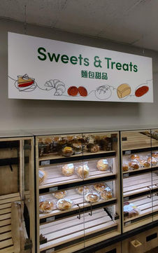 A hanging bakery sign inside Meiga Supermarket