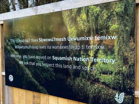 A welcome sign printed on coroplast attached to the wall at Squamish Canyon
