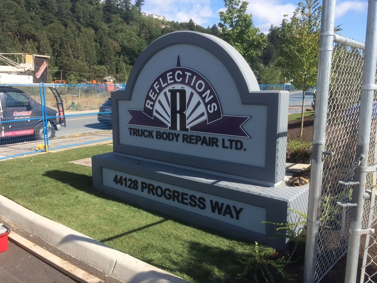 A permanent concrete monument sign with dimensiona letters and logo on it.webp