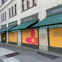 Multiple awnings with a valance covering the streetside of Louise Vuitton retail store