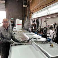 Century Signs staff member building a custom lightbox frame inside their sign shop