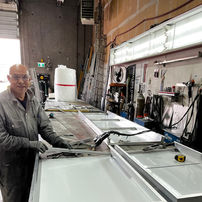 Century Signs staff member building a custom lightbox frame inside their sign shop