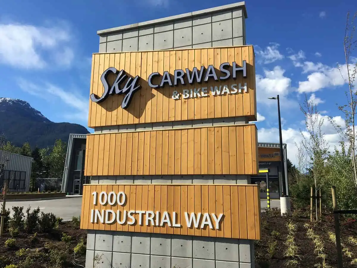 A massive pylon sign with various dimensional letter business names on it.webp