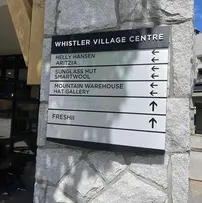 Exterior wayfinding sign at the entrance of Whistler Village Centre to direct people