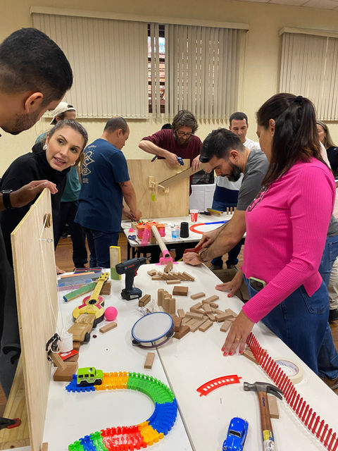 Integração de equipe com dinâmica ChainReaction, com a equipe construindo sua estação