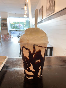 Iced coffee with chocolate drizzle and whipped cream