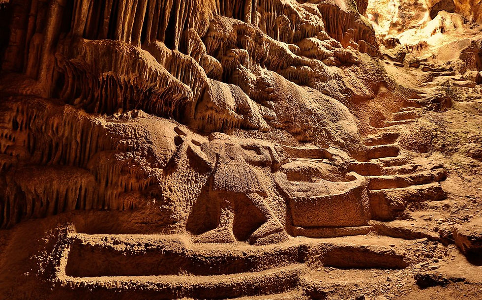 Carving of a person in a pan's cave wall, surrounded by stalactites. The earthy tones and textured surfaces evoke an ancient, mysterious mood.