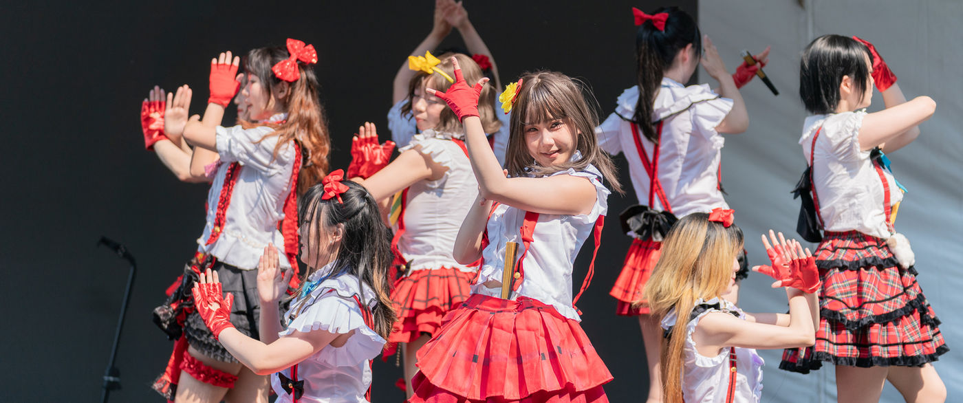 A dance group performing on the festival main stage in front of a large crowd
