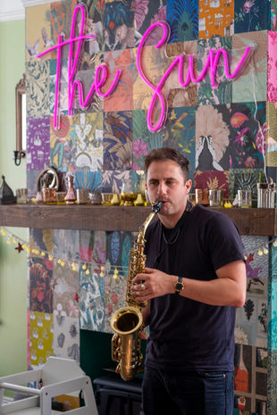 Male saxophone player at a birthday party.  