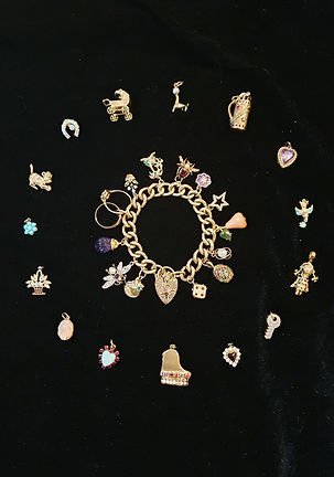 A picture showing a stunning array of vintage gold charms set with precious gems