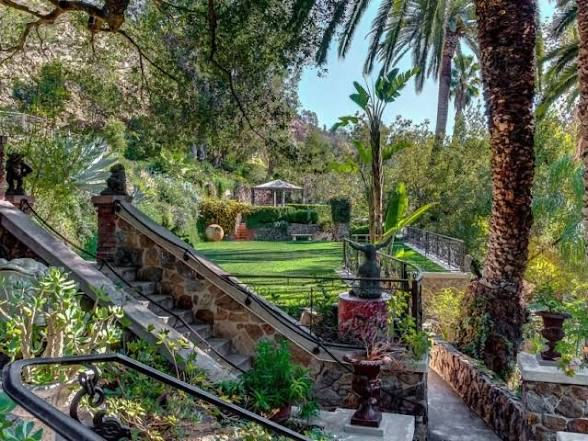 Stone stairs, lawn, gazebo, palms, and garden railings at the estate