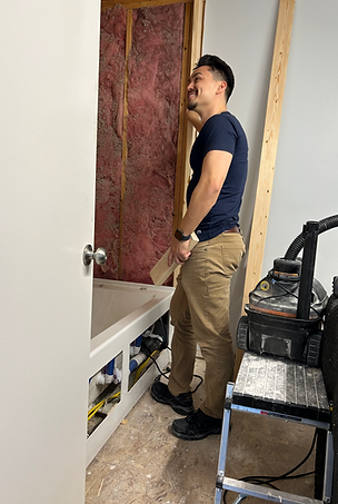 Man smiling while working on a bathroom renovation project.