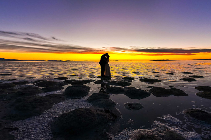 Bride and groom at sunset at antelope island silhouetted. 
