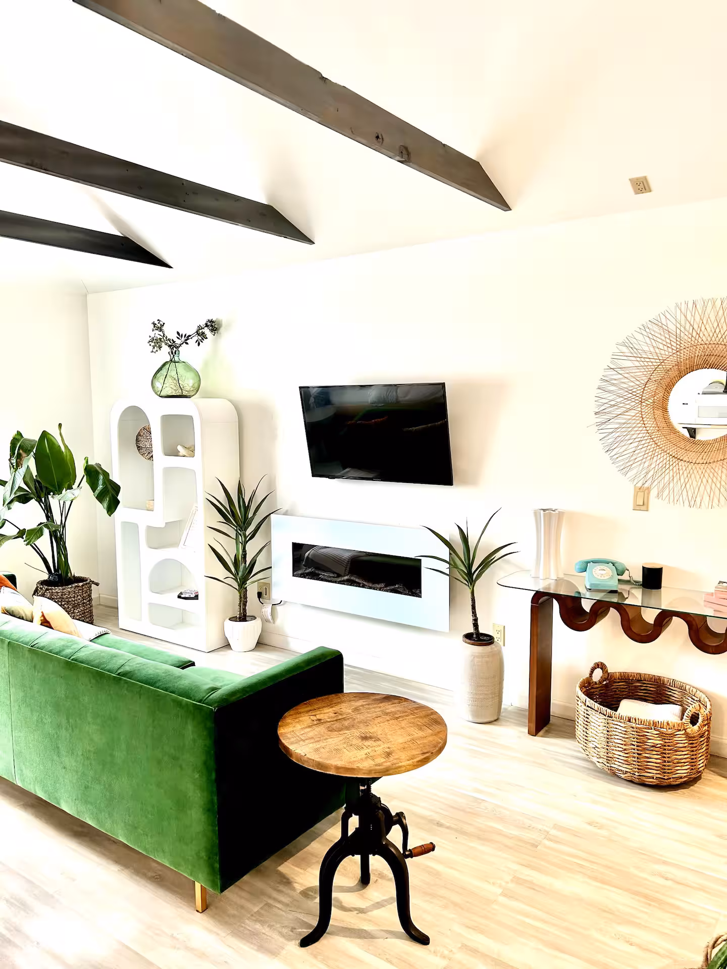 A cozy living room with a bright, airy aesthetic. Includes a green velvet couch, mid-century modern furniture, and minimalistic décor, ideal for portrait sessions