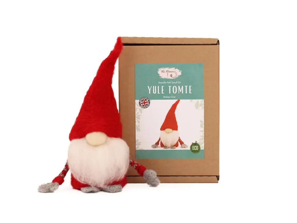 Tomte in red sitting beside a brown craft box showing a label of the kit