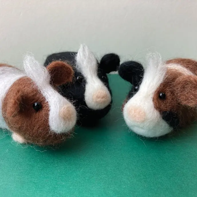 Three needle felted guinea pigs in black and white and brown