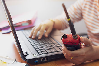 Female radio operator using Walkie - Talkie to communicate with other people and typing on