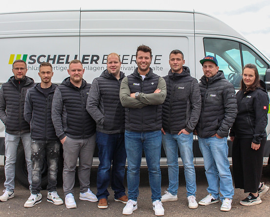 Das Team von Scheller Energie vor ihrem Fahrzeug, bereit für die Installation von Photovoltaikanlagen.