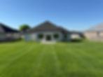 Established green residential lawn behind a newly built home