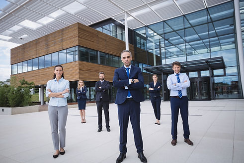 group-confident-businesspeople-standing-outside-office-building.jpg
