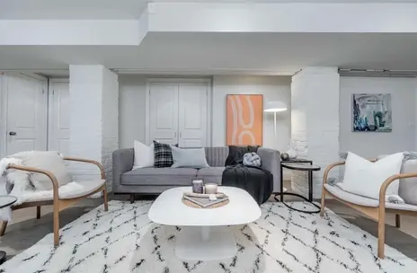 Finished basement living room with freshly painted walls and a bright, inviting atmosphere.