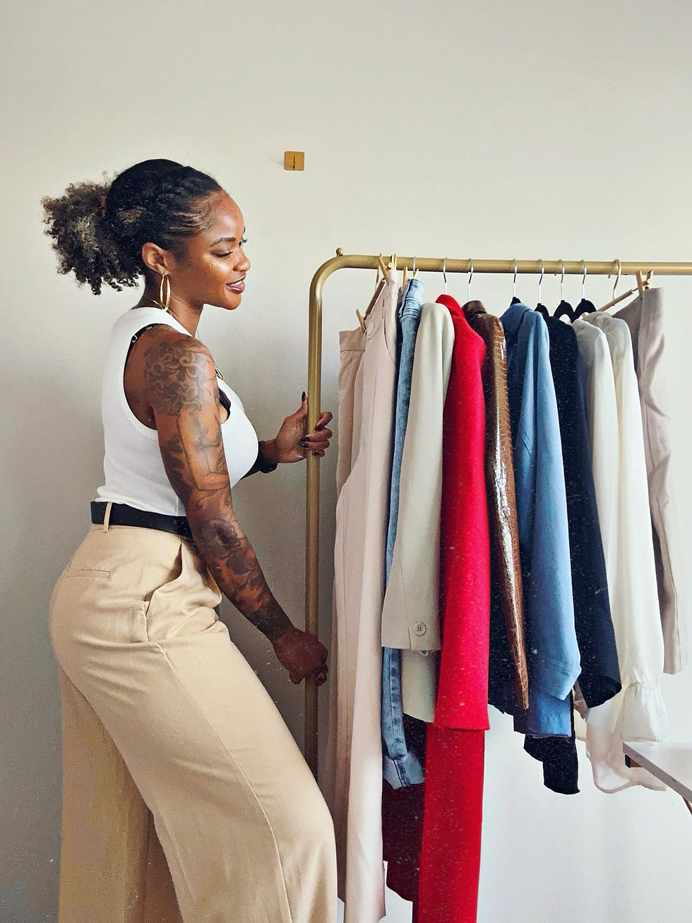 Tierra Cobb pushes a rack of vintage clothing, highlighting her curated finds and stylish selections for her resale brand, Girls World Thrift.