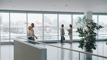 Zoom-in of man and woman business people talking in lobby discussing work while colleagues